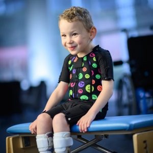 Boy in black body splint with smiley face design pattern