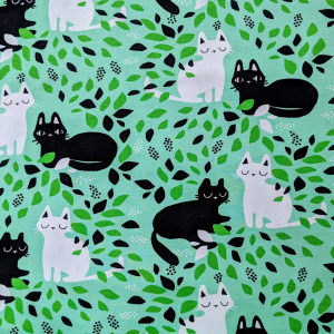 Fabric swatch with white and black kittens on a mint coloured background